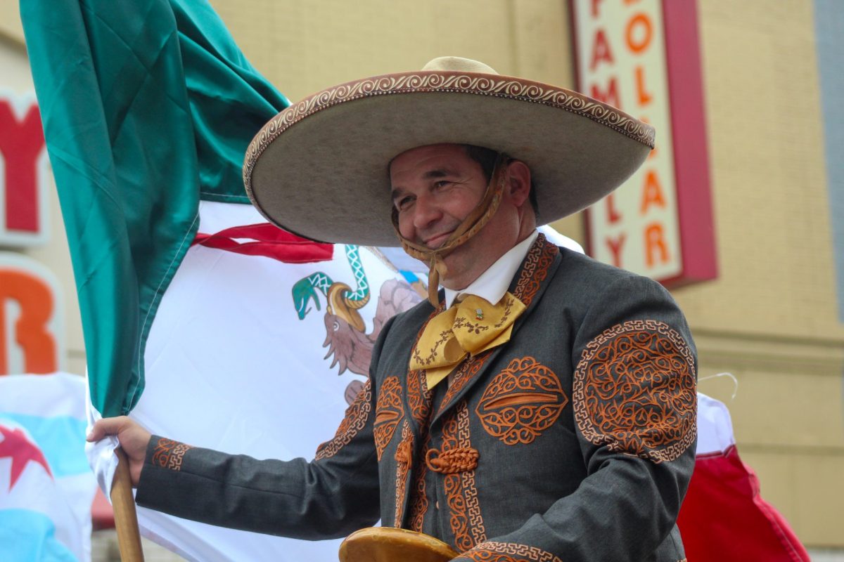Un asistente al desfile monta a caballo y sostiene una bandera mexicana durante el desfile de la Independencia de México el 16 de Septiembre.