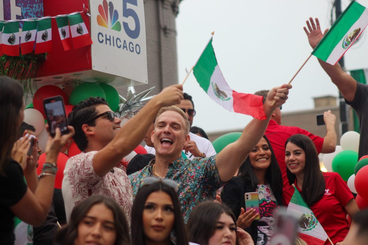 Un grupo de personas en la carroza de NBC y Telemundo ondean banderas mexicanas durante el Desfile de la Independencia de México el 16 de septiembre.