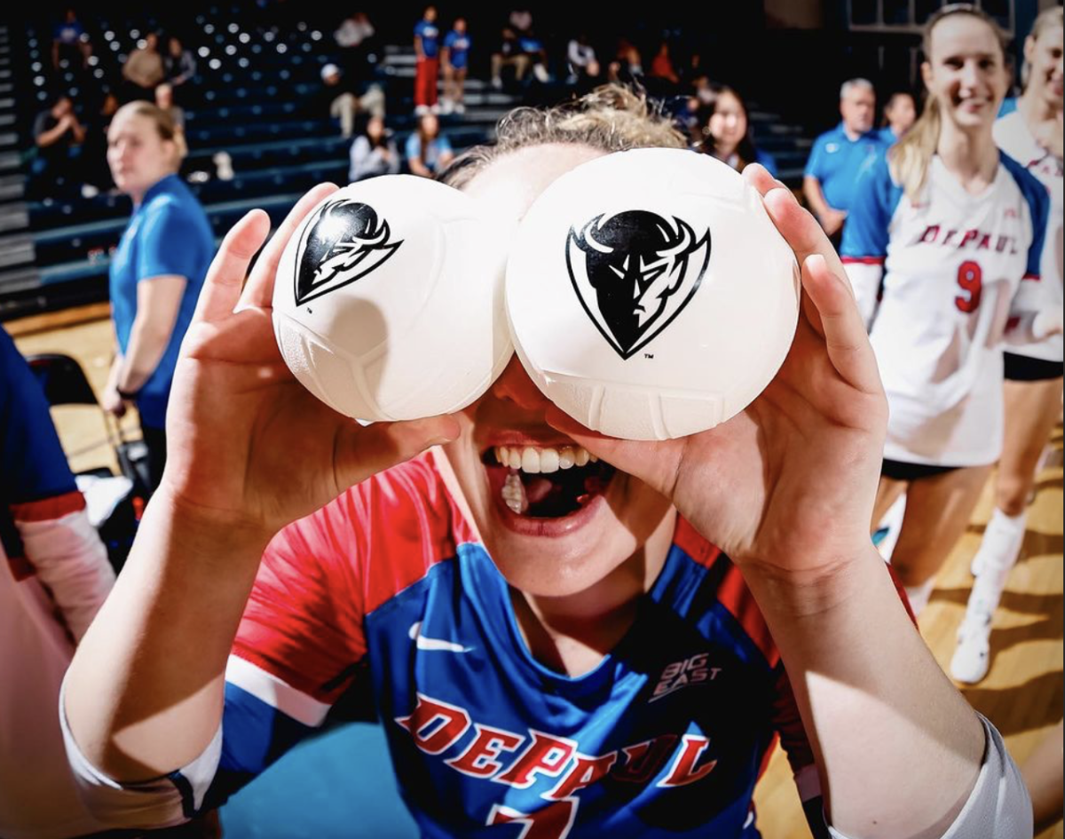 Rachel Krasowski, DePaul women’s volleyball libero and senior, holds two mini volleyballs to her eyes at the Sept. 7 game against Northern Illinois University. Before playing, the volleyball team threw mini volleyballs into the crowd.