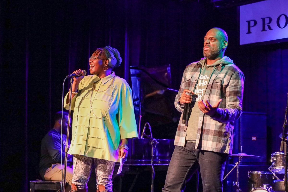 Christopher LeMark (right) and emcee The Last Poet speak at a fundraising concert Oct. 11, 2023, in Chicago. The proceeds from the fundraiser go to Coffee Hip Hop & Mental Health and their free therapy program.