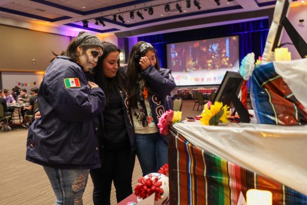 Isabella Esquivel, Savannah Mireles y Shayla García lloran por sus seres queridos en el evento del Día de Muertos el 2 de noviembre en DePaul. Son hermanas de la hermandad de Gamma Phi Omega, consolándose mutuamente.