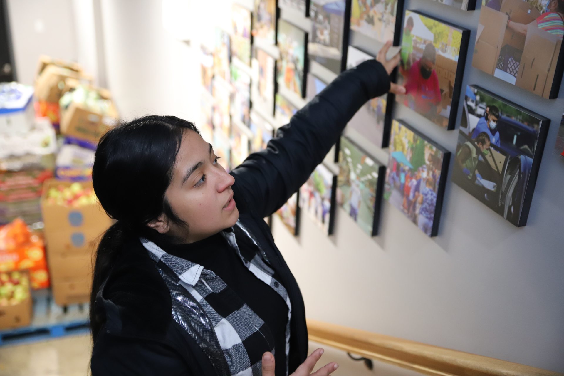 Diana Franco, the coordinator for Pan de Vida, looks at pictures and talks about the history of the food pantry in Little Village on Nov. 1. Franco has been working with Pan de Vida for years now and said she loves giving back to her community.