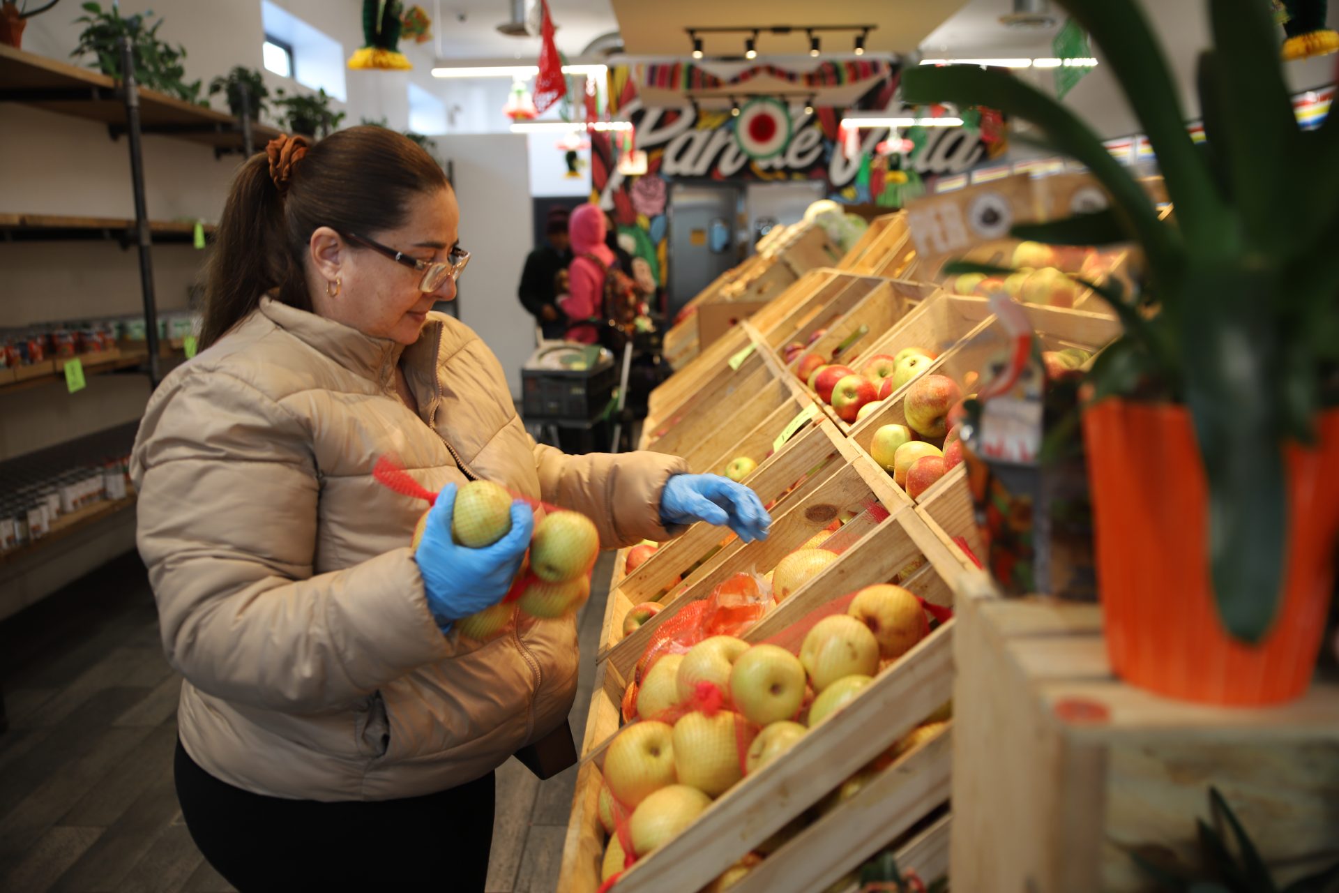 Sandra Helena Alves Da Silva pone manzanas en Pan de Vida el 1 de noviembre. Alves Da Silva comenzó a venir a la despensa de alimentos alrededor de mayo de 2023, y ahora dijo que está feliz de trabajar en la tienda y retribuir a su comunidad.