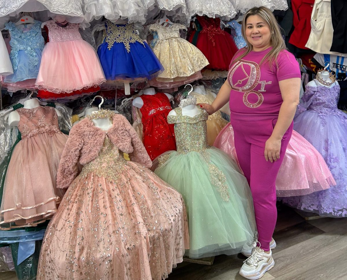 Bertha Verónica Ramírez junto a su mercancía en su tienda Veros Kids y Hulama el 4 de febrero de 2024. Mantuvo una sonrisa, con la esperanza de que los clientes pasaran por allí.