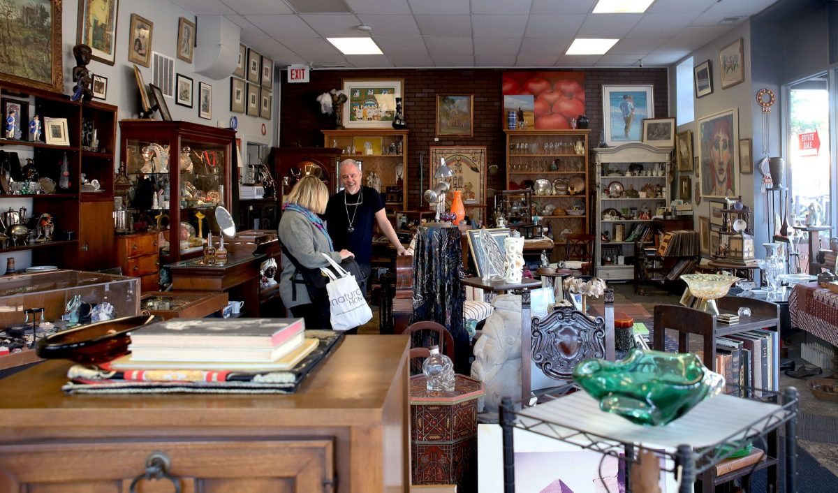Richard Wilford talks with a customer in his Edgewater storefront on Oct. 22, 2023. Every item in the store, from Tiffany jewelry boxes to Beanie Babies, is handpicked from local families estates. 