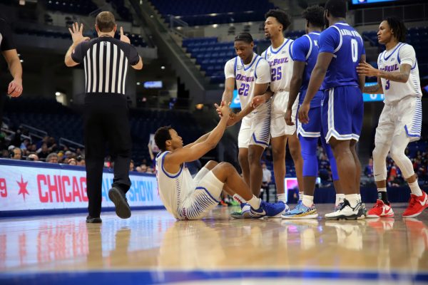 Elijah Fisher, 22, helps his teammate Churchill Abass to his feet in a game against Seton Hall Tuesday, Jan. 30, 2024, at Wintrust Arena. Abass and Fisher were held to a combined 10 points between them.
