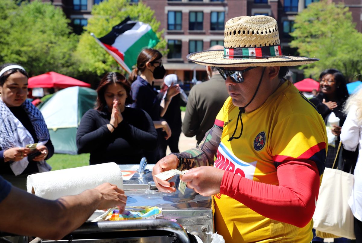A paletero sells ice cream to students at the encampment on Tuesday, April 30, 2024, at DePaul University. There was various different food options for the demonstrators. 