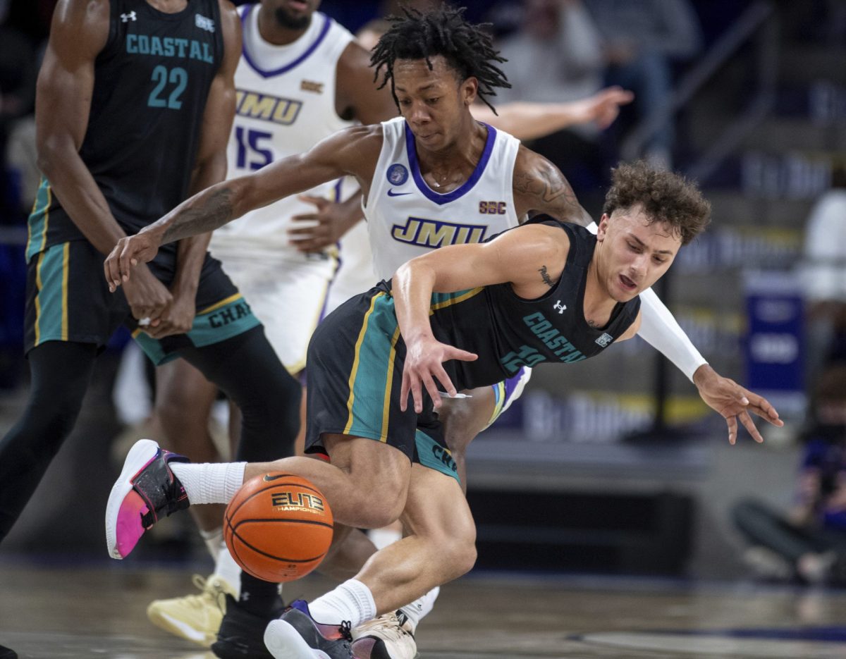 Coastal Carolina guard Jacob Meyer (12) loses control of the ball against James Madison forward Raekwon Horton during the second half of an NCAA college basketball game in Harrisonburg, Va., Thursday, Feb. 1, 2024.