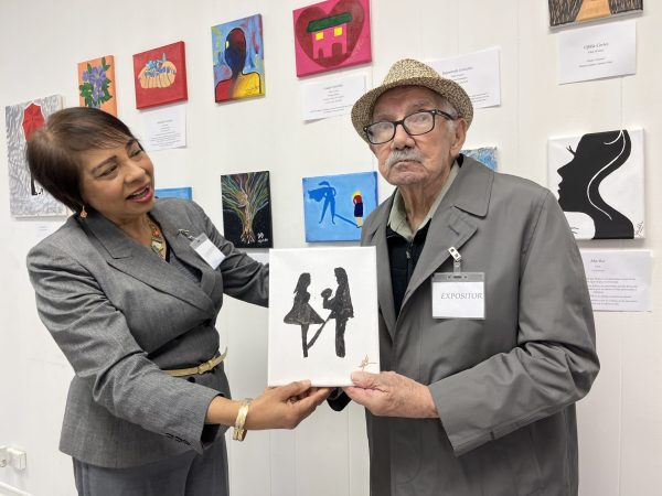 Reyna De Jesus and her father, Raymundo Gonzalez, presents his art at LAMDA Headquarters in Cicero, Ill., March 8, 2024. Seniors are learning to cope with memory loss through painting at the LAMDA art exhibition. 