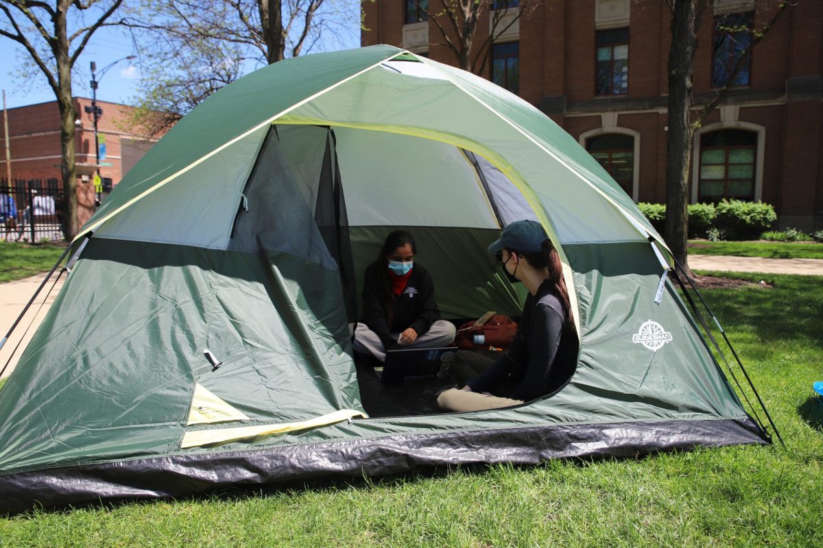 DePaul students do homework in tents, acting in solidarity with the pro-Palestinian encampment on the Lincoln Park Campus Quad, on April 30. 