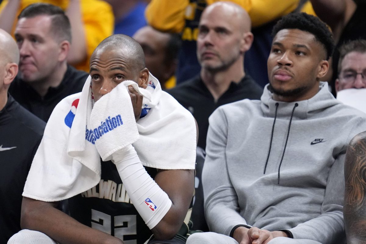 Milwaukee Bucks forward Khris Middleton (22) watches from the bench with teammate Giannis Antetokounmpo, right, during the second half against the Indiana Pacers in Game 6 in an NBA basketball first-round playoff series, Thursday, May 2, 2024, in Indianapolis.