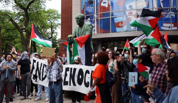 Pro-Palestine protestors stand around the statue of Monsignor Egan outside of the Student Center during the DePaul Divest Coalitions press conference on Thursday, May 16, 2024. Student leaders and members of the encampment and DePaul community spoke during the press conference, stating that even if the encampment was gone, they would continue fighting for divestment.
