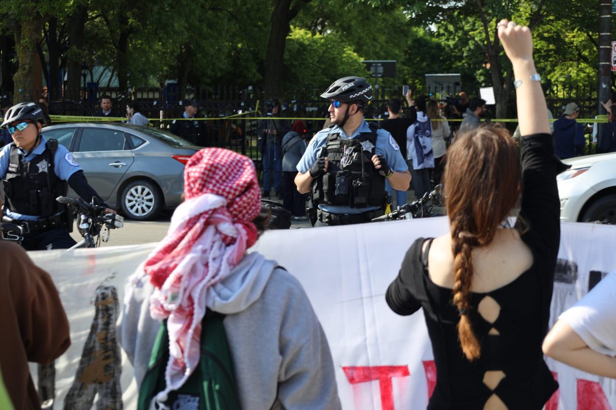 Pro-Palestine protestors chant at a row of Chicago Police Department near the intersection of Seminary and Fullerton by a gas station May 16, 2024. Officers formed a line to block access to the Quad while the encampment was cleared.