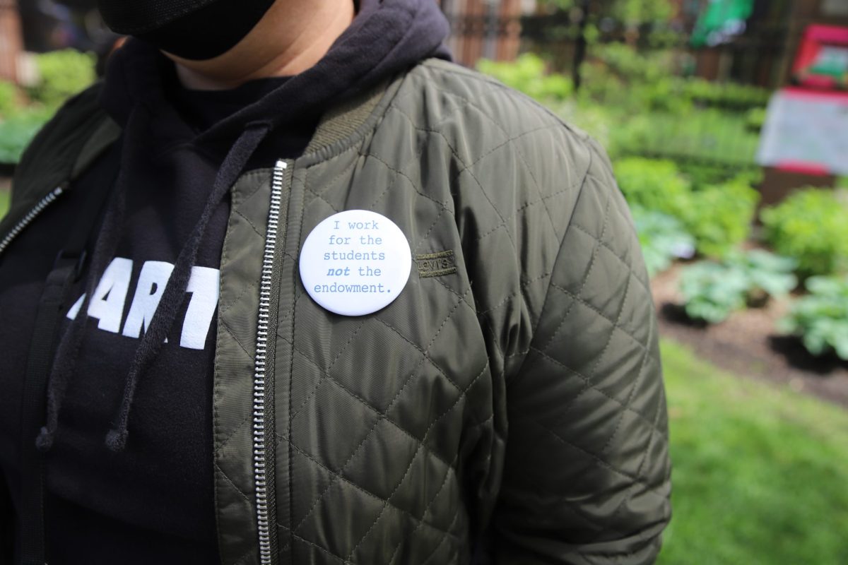 A professor wears a button, “I work for the students not the endownment,” as they stand on the Quad with other faculty in support of the encampment, May 2, 2024.  