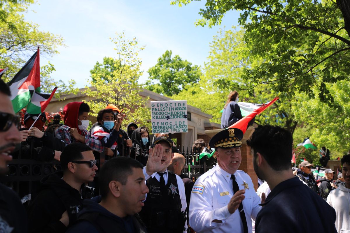 A CPD commander, Michael Barz holds back pro-Israel counter-protestors at the Fullerton entrance to DePauls Quad, May 5, 2024. CPD has shut down the side walk to pedestrians as as tensions rise. 