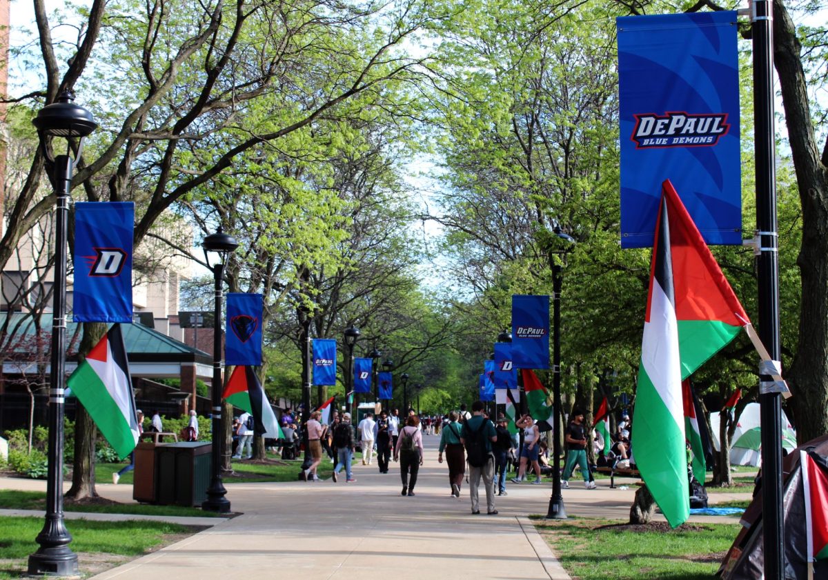 Protesters and commuters travel down the main sidewalk of DePaul Universitys Quad on Wednesday, May 1, 2024. On the opposite end of the quad, organizers served dinner to demonstrators and a handful of community members brought by donations of toiletries, food, water and other supplies.