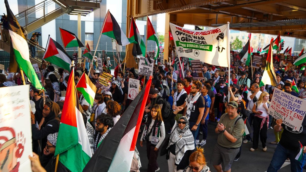 Pro-Palestinian protesters march under the Lake Street "L" as they march around the DNC on Thursday, Aug. 22, 2024.