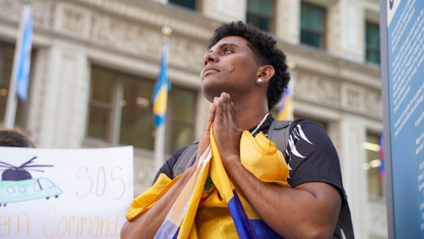 A protester holds his hands in a sign of prayer as he holds a Venezuelan flag on Wednesday, July 31, 2024, during protest in 'Plaza las Americas', downtown Chicago.