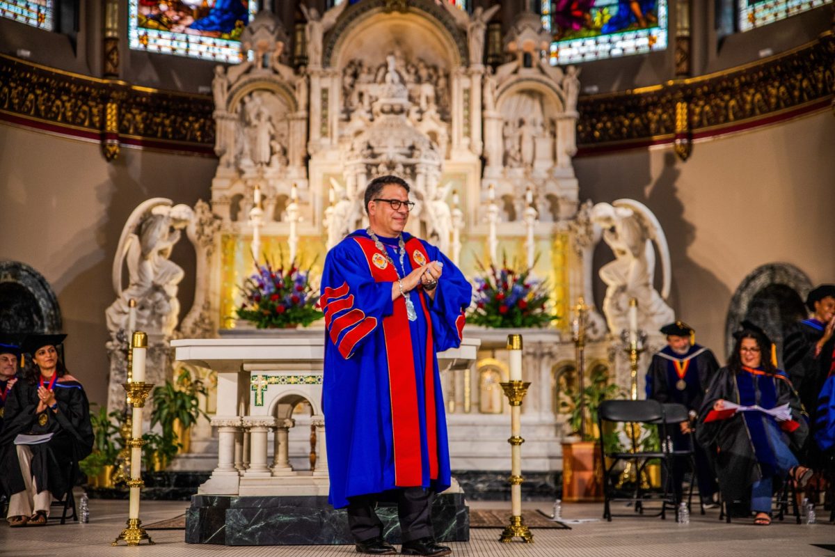 President Robert Manuel claps as faculy and staff are honored with the Spirit of DePaul award at during the Academic Convocation at St. Vincent de Paul Catholic Church in Lincoln Park on Aug. 29, 2024. In this past, Manuel's speeches have focused on DePaul's finances, but this year was centered on dialogue and the campus community.  