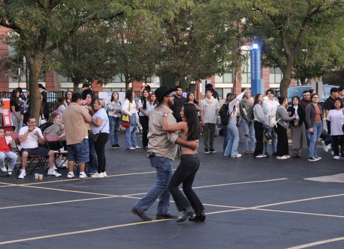 Una pareja baila en la tercera “Feria” del Centro Cultural Latinx el jueves 26 de septiembre de 2024 en el estacionamiento del Centro de Bienvenida del campus Lincoln Park de DePaul.