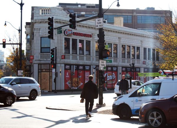 Cars drive by and people walk in front of the new Raising Cane's location on Friday, Nov. 1, 2024, in Chicago. The new location is at Lincoln Common, directly across the street from DePaul’s Holtschneider Performance Center. 