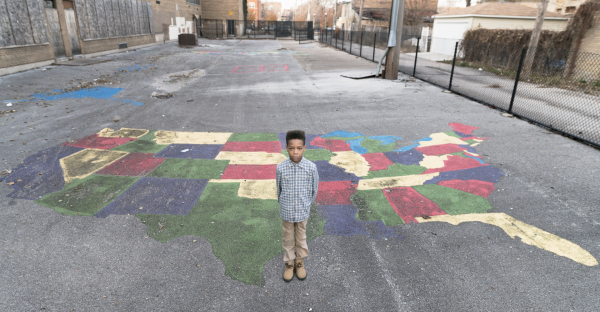 Solomon Bobo, son of former CPS educator Darnell Bobo, stands in front of map artwork, part of the vacant Betsy Ross Elementary school. Both Bobos are subjects of Austin Pope's 'The (Mis)Education of Chicago' portrait series, which focuses on nearly 50 Chicago public schools shut down in 2013. 