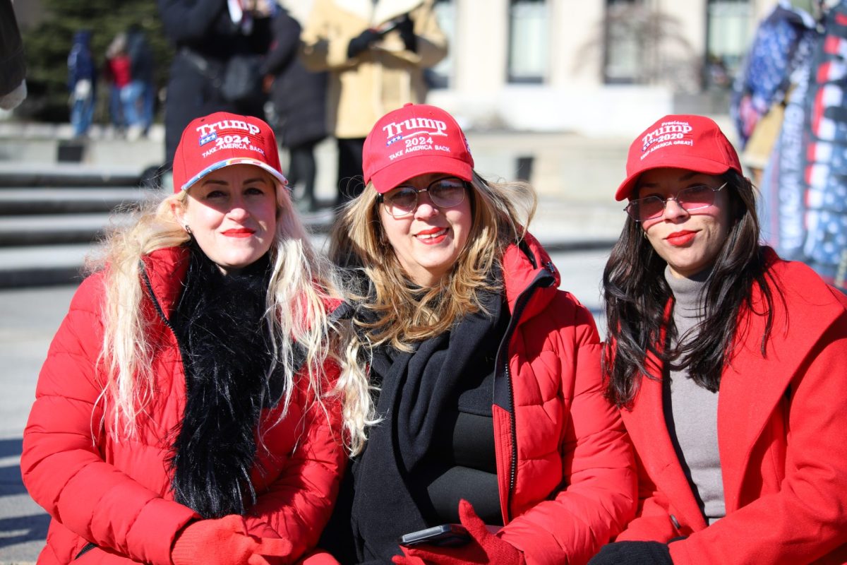 From L-R: Sandra Cabrea, Chabela Rodriguez and Roxany Perez pose for the camera in front of the motorcade fence going down Pennsylvania Avenue on January 20, 2025. They all travelled from Miami to attend President Trump's inauguration