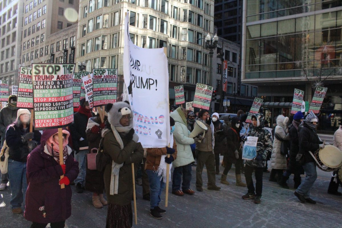 Protestors march down State St. holding signs against the newly inaugurated President Donald Trump. The demonstrators marched in Downtown Chicago towards Trump Tower.