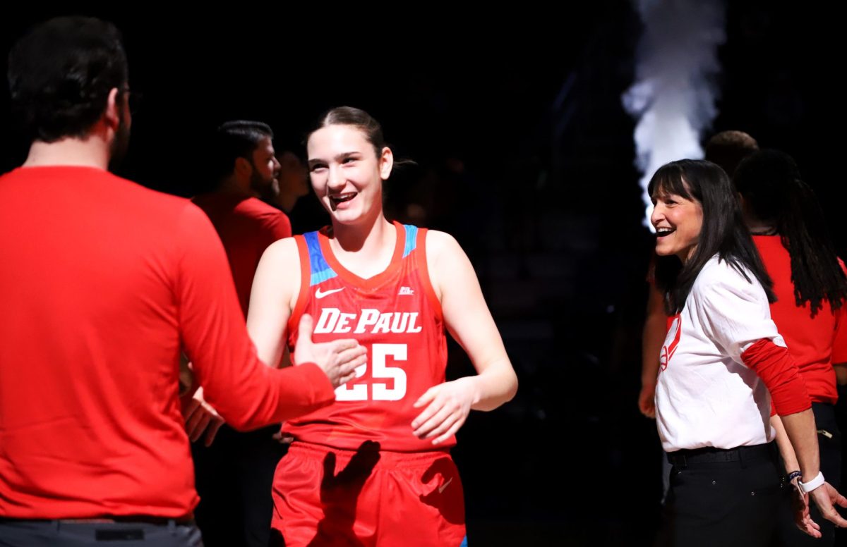 Kate Clarke runs through the tunnel, debuting her new red uniform, at the start of her game on Wednesday, Jan. 22, 2025, at Wintrust Arena. DePaul wore red uniforms to honor their late former assistant coach, Maggie Dixon.