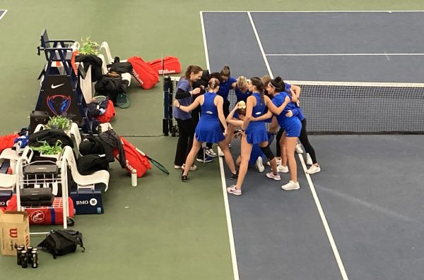 DePaul women’s tennis players huddle before their doubles matches against UIC at XS Tennis Village on Saturday, Jan. 25, 2025. “I think if we show up with a good attitude, good energy … then we’ll keep getting better and have the most chance for success,” head coach Marisa Arce said. 