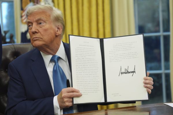 President Donald Trump holds a signed executive order on deregulation in the Oval Office of the White House, Friday, Jan. 31, 2025, in Washington. 