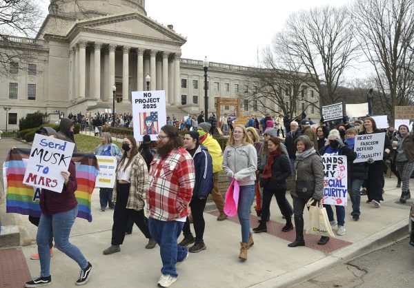 Protesters holding signs march around the West Virginia Capitol following a 50501 Protest on the south steps of the Capitol in Charleston, W.Va., on Wednesday, Feb. 5, 2025, during what was billed as a nationwide series of protests against President Donald Trump, Project 2025, DEI rollbacks and other recent administration initiatives.