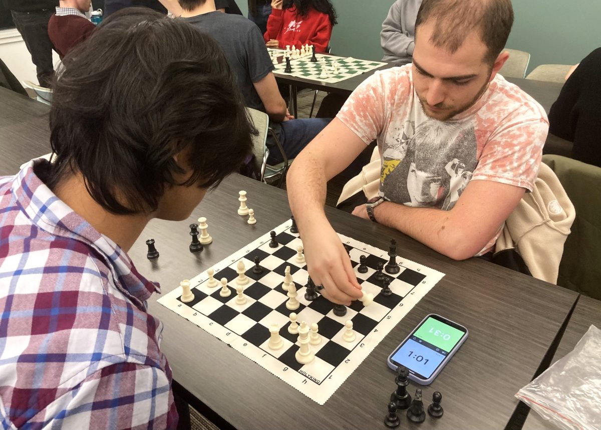 Junior Nate Lanier (right) captures a piece against sophomore Mohid Siddiqui (left) in a bullet game at the DePaul Chess Club on Thursday, Jan. 16, 2025. Lanier considers chess a sport due to its strenuous mental requirements, with the body being an extension of the mind. 