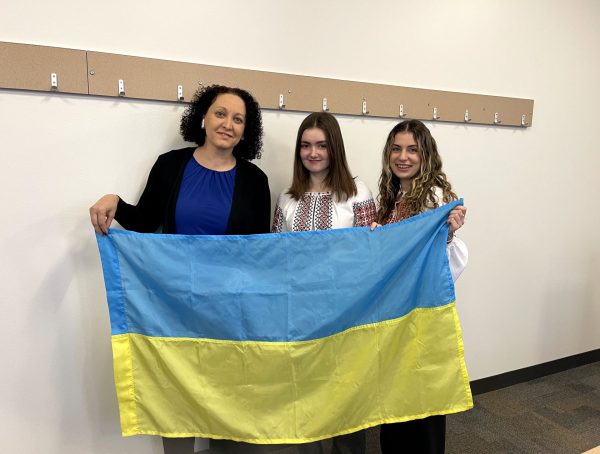 Olya Glantsman, faculty advisor for the Ukrainian-American Cultural Association at DePaul, poses with the Ukrainian flag next to president Viktoriia Stelmakh and vice president Anastasiia Volyk at the global conference on Feb. 21, 2025.