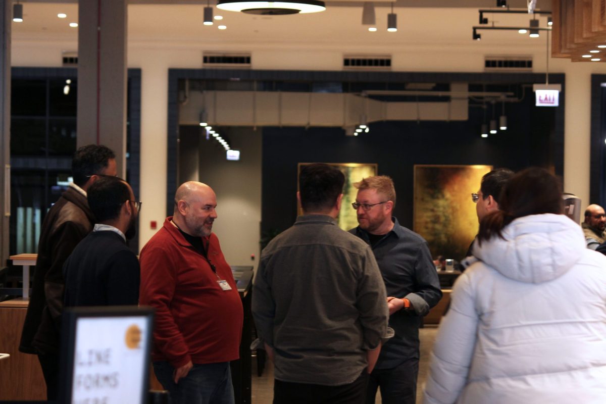 A group of coworkers converse in the corridors between restaurants at From Here On on Thursday, Feb. 20, 2025. The venue was a project from 16" On Center, a hospitality collective which aids in the construction of local food markets around Chicago. 