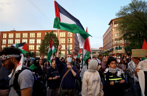 A pro-Palestine protester waves a Palestinian flag on Fullerton Avenue during the rally on Thursday, May 16, 2024. Over 300 demonstrators walked around DePaul's Lincoln Park campus while neighborhood residents and CPD officers watched.