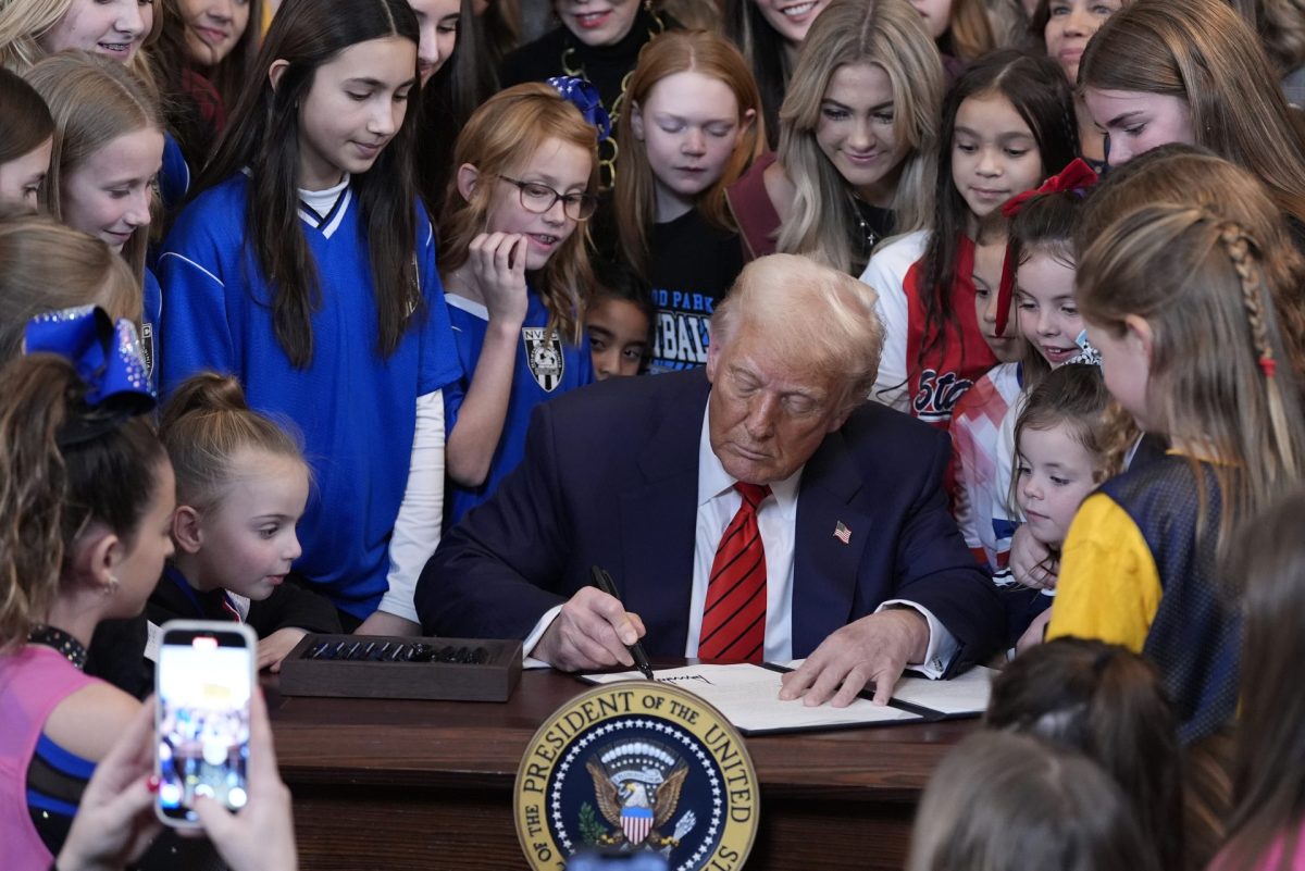 President Donald Trump signs an executive order barring transgender female athletes from competing in women's or girls' sporting events, in the East Room of the White House, Wednesday, Feb. 5, 2025, in Washington.