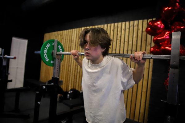 KJ Ulrick practices squatting on Saturday, Feb. 15, 2025.  While they prepare relentlessly, stereotypes on women who powerlift persist.