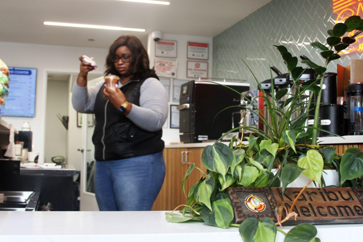 Abby Abuya, barista at Kikwetu Coffee Company, finishes making a coffee for a customer on Wednesday, Feb. 19, 2025, inside SPF Chicago. Abuya provided the pickleball club patrons with a unique cultural beverage in between matches.