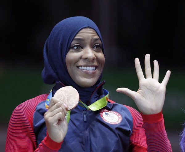 Ibtihaj Muhammad of the United States pose with her bronze medals on the podium after the womens team sabre fencing event at the 2016 Summer Olympics in Rio de Janeiro, Brazil, Saturday, Aug. 13, 2016.
