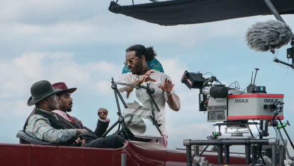 Director Ryan Coogler speaks with actors Michael B. Jordan and Delroy Lindo on the set of “Sinners.” The film, an action-horror story set in the Depression-era south, was shot on 70mm IMAX film cameras, allowing for a more open frame.