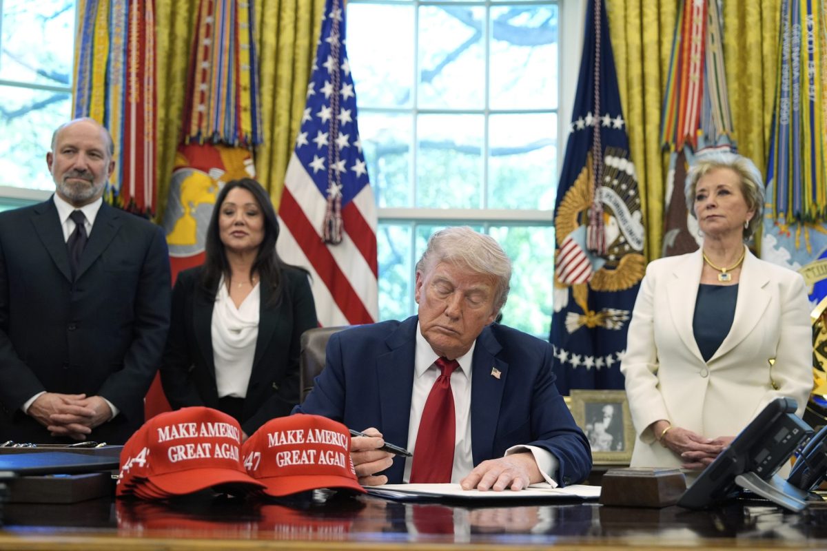 President Donald Trump signs an executive order regarding education in the Oval Office of the White House, Wednesday, April 23, 2025, in Washington, as Commerce Secretary Howard Lutnick, Labor Secretary Lori Chavez-DeRemer and Education Secretary Linda McMahon watch. 