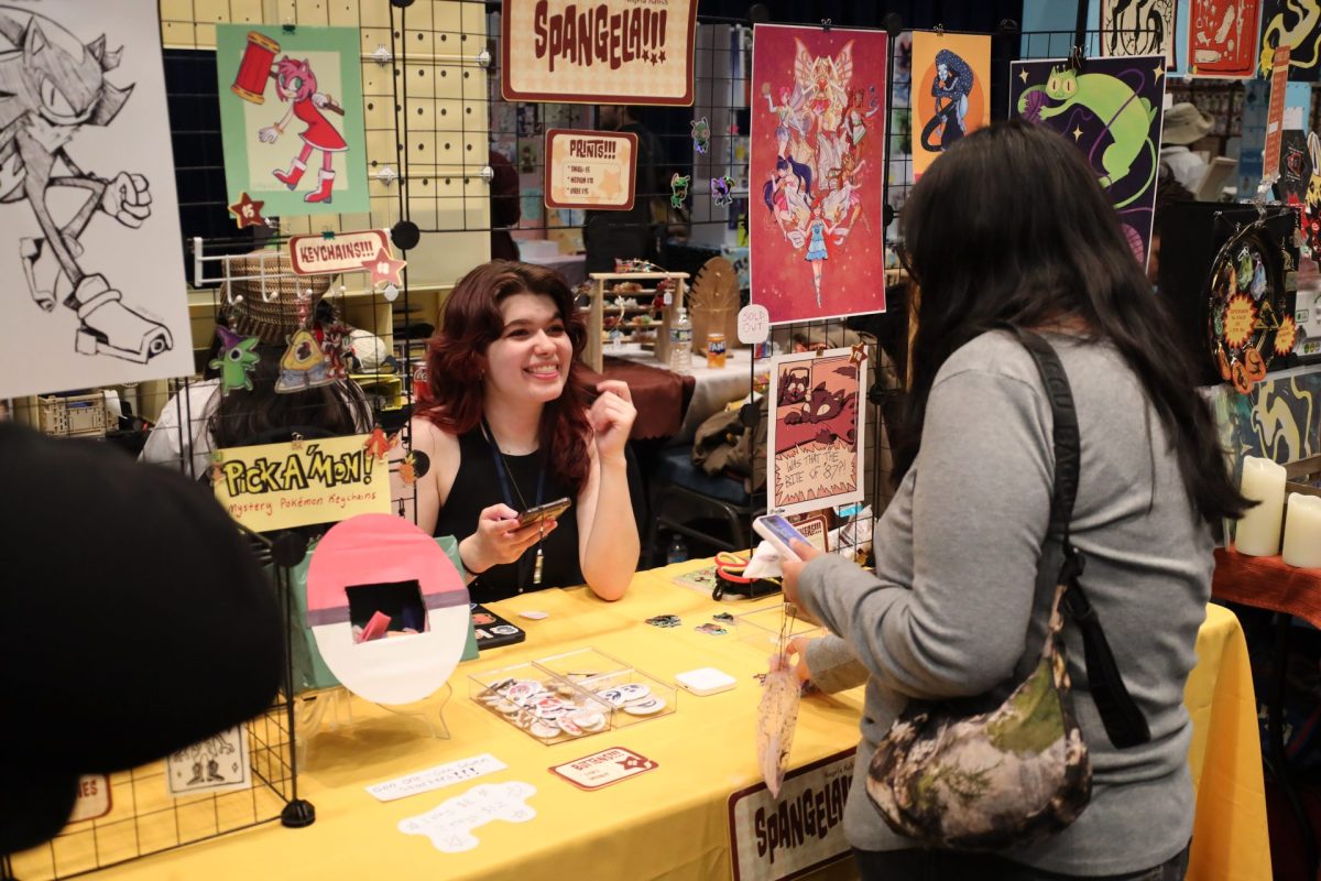 Angela Kalish, owner of Spangela sells items to a customer at her booth at DIBScon on Saturday, May 24, 2025. Spangela is a Chicago-based shop that sells original prints, stickers and keychains.