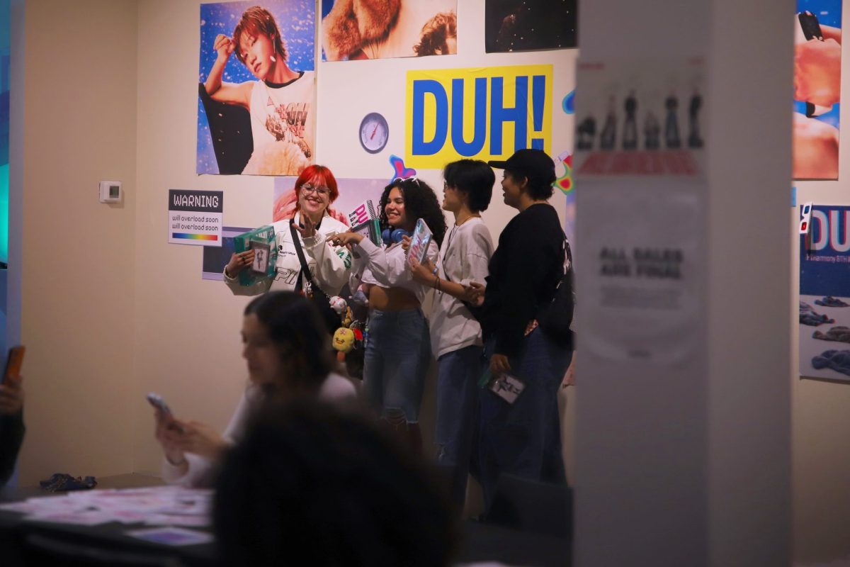 Anna Alatato, left, Paola Munoz, Mar Burch and Mercury Ragland stand in front of a P1Harmony display created by Hello82 at their pop-up event on Saturday, May 10, 2025. In addition to P1Harmony, Hello82 has hosted pop-up events for alternative K-pop groups such as The Boyz, Xikers and Tomorrow X Together.