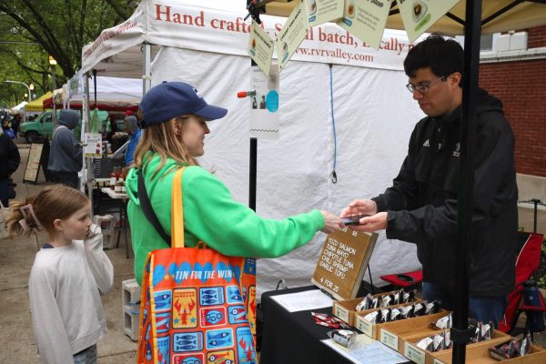 Carlos Maxwell, a market vendor for Onigiri Kororin, makes a sale to a customer at The Uptown Farmers Market on Wednesday, May 21, 2025. Onigiri Kororin is offered at more than 60 stores across the Chicago area.