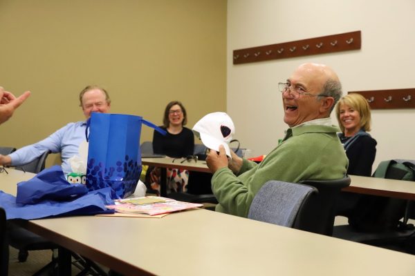 Rick Brown opens gifts from colleagues during his last journalism department meeting at DePaul's Loop Campus on Friday, May 30th, 2025. "I get emotional talking about the students – they're just so amazing," Brown said.