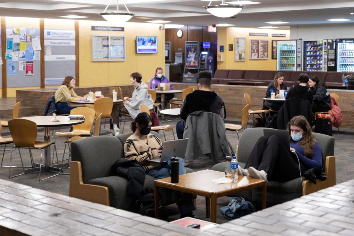 File- A mix of masked and unmasked students sit in the Schmitt Academic Center on March 13, 2022. While the mask requirement at DePaul ended in 2022, some students still choose to wear masks on campus. 