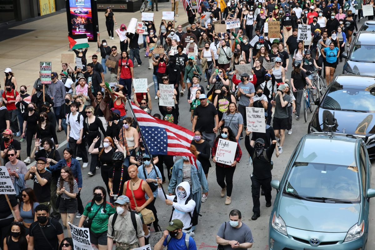 Manifestantes contra las redadas de ICE marchan en el casco urbano de Chicago el 10 de junio de 2025. Una pancarta dice “Los inmigrantes hacen grande a Estados Unidos”, en referencia al eslogan presidencial de Trump, “Hacer a Estados Unidos grande otra vez”.