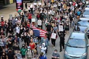 Manifestantes contra las redadas de ICE marchan en el casco urbano de Chicago el 10 de junio de 2025. Una pancarta dice “Los inmigrantes hacen grande a Estados Unidos”, en referencia al eslogan presidencial de Trump, “Hacer a Estados Unidos grande otra vez”.