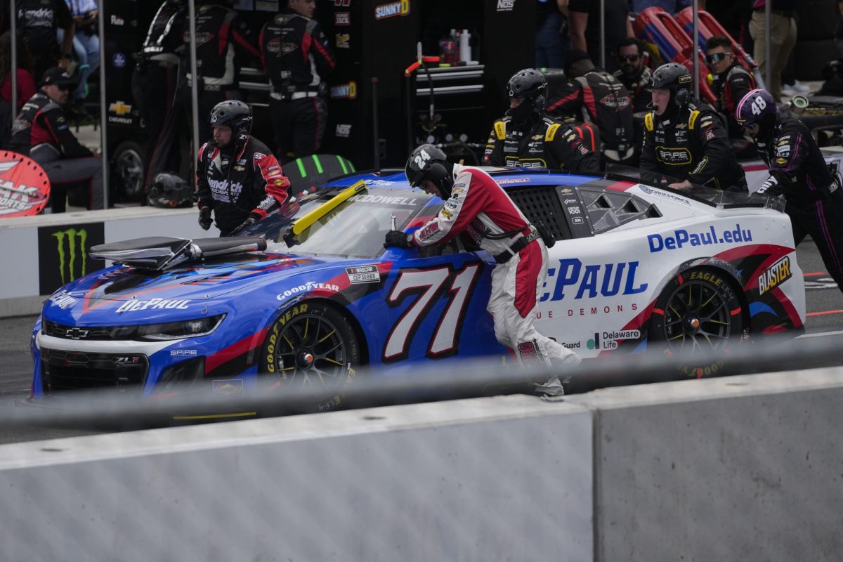 Crew members push Michael McDowell's car along pit road during a NASCAR Cup Series auto race at the Grant Park 165, Sunday, July 6, 2025, in Chicago. (AP Photo/Erin Hooley)